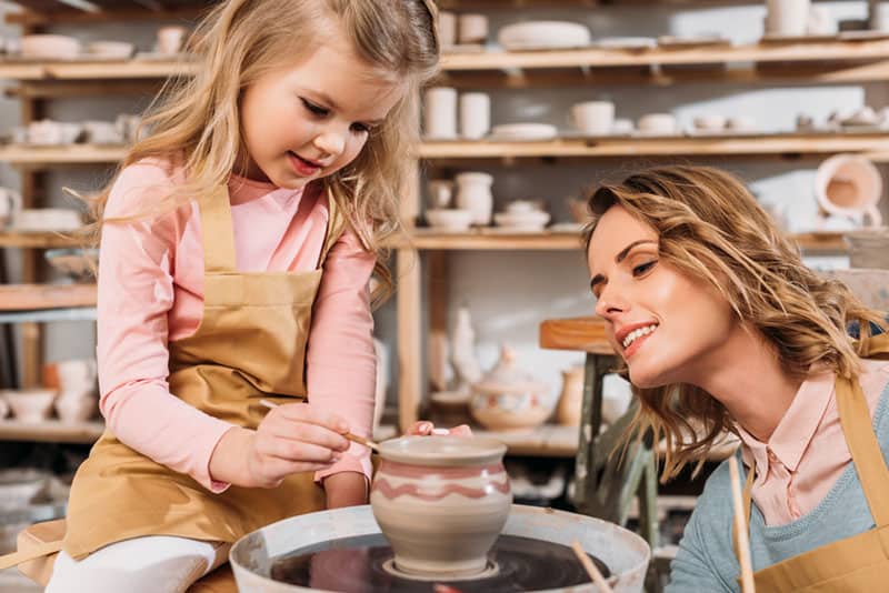 mother and daughter painting ceramic pot