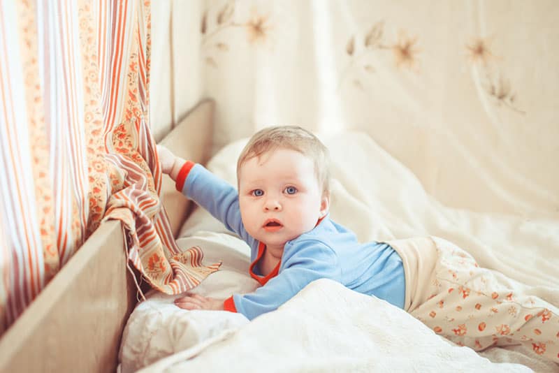 child playing in bed