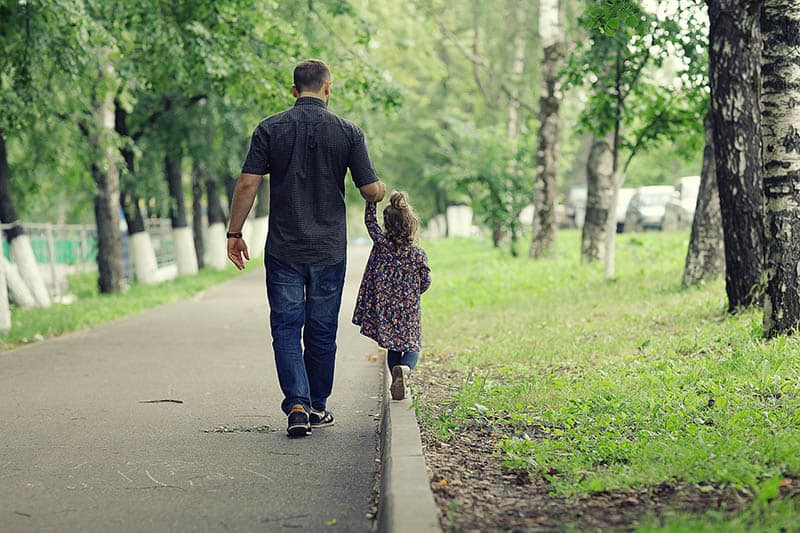 father and kid taking a walk in a park