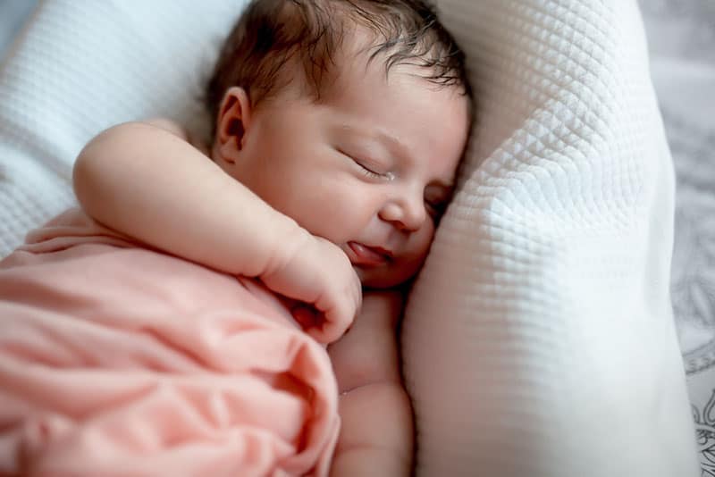 Cute baby sleeping on white pillow