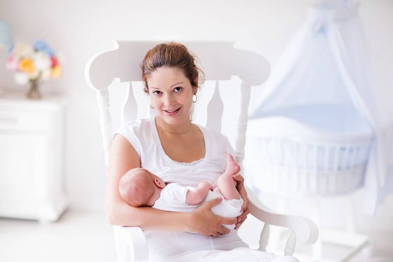 young mother posing with baby on the chair
