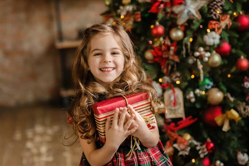 cute little girl holding christmas present