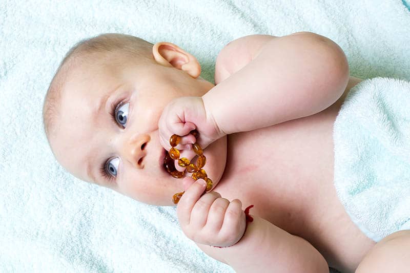 Baby with Amber Teething Necklace chewing
