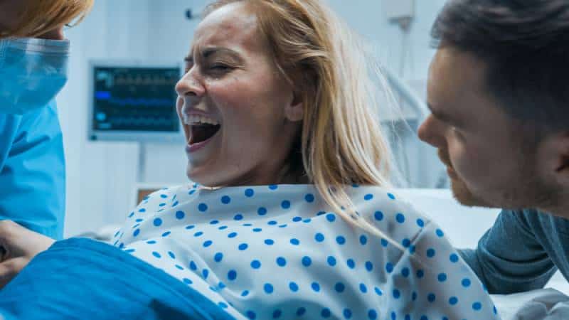 Woman in Labor Pushing Hard to Give Birth in a hospital