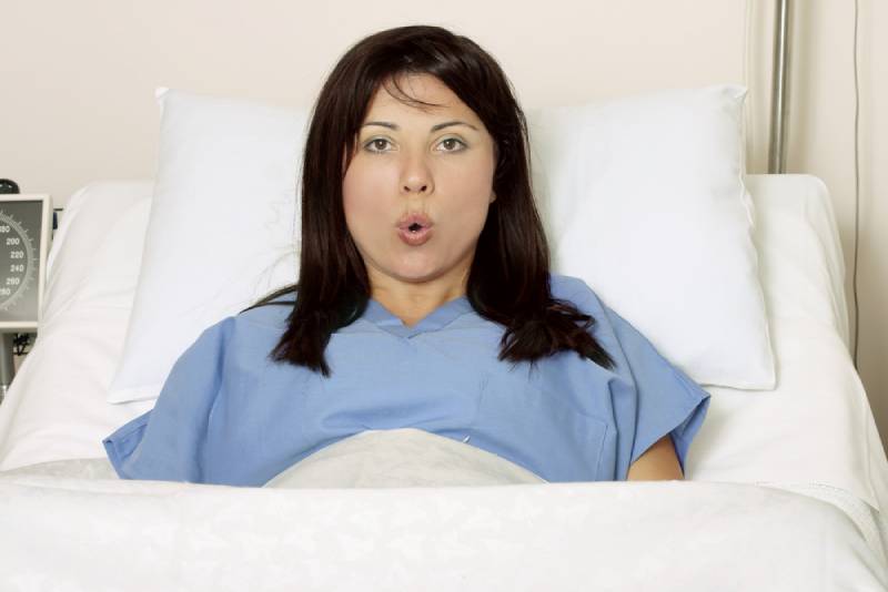 Woman taking long breaths while being in hospital