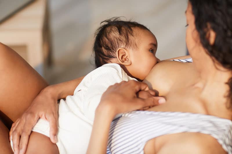 woman breastfeeding beautiful baby