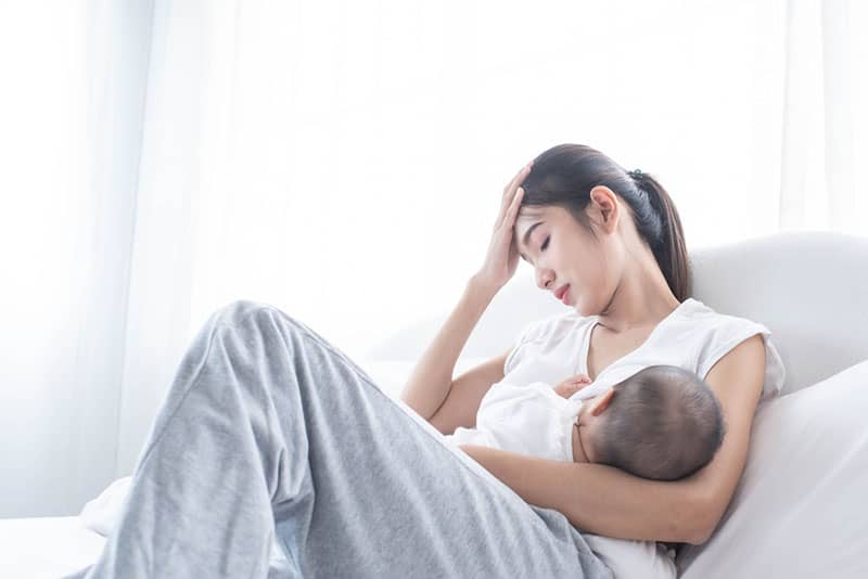 worried woman breastfeeding baby