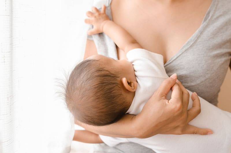 young mother trying to breastfeed her baby