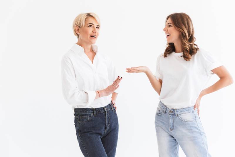 2 happy women talking on white background