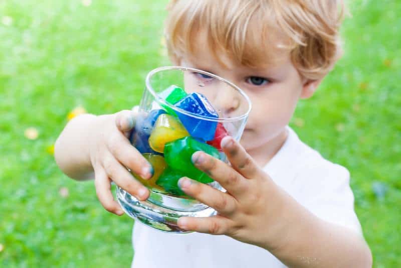 Boy with colorful ice cubes outdoors