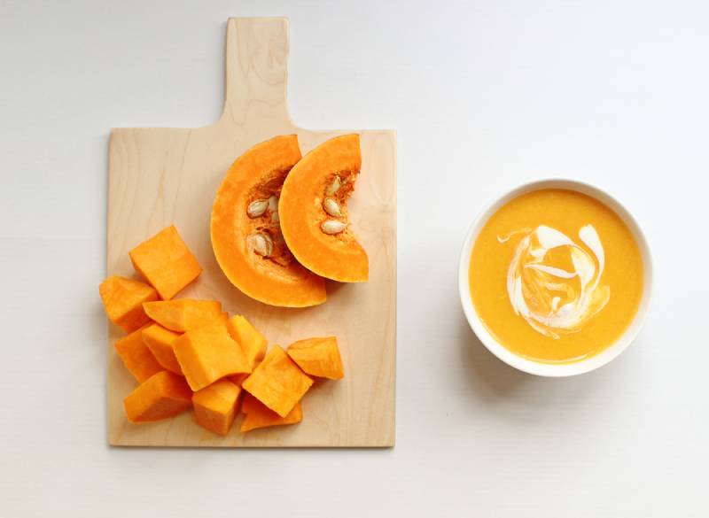 Bowl of butternut squash soup on a white background,