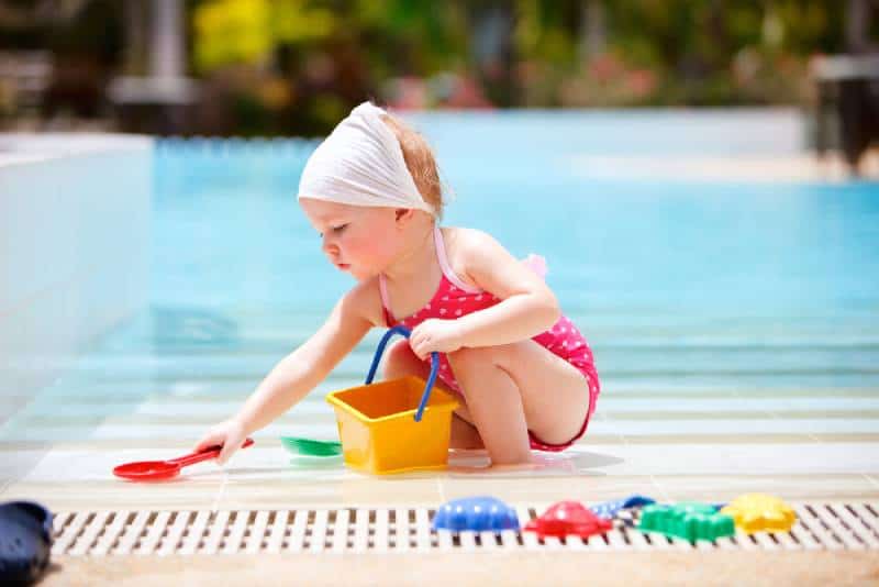 Cute toddler girl playing in swimming pool
