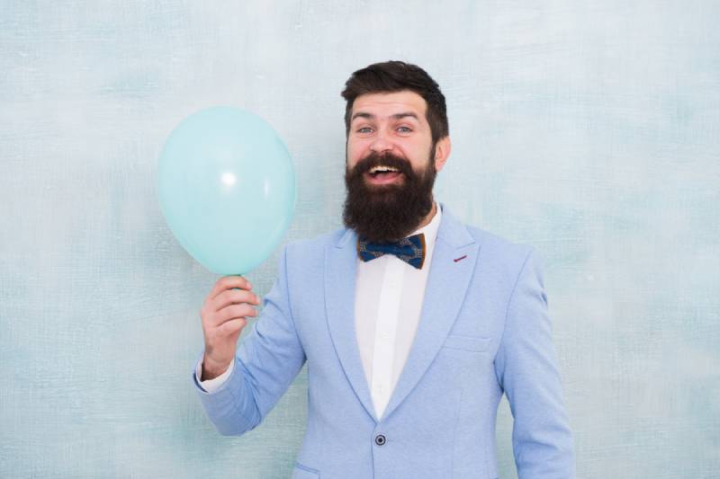 Man in blue tuxedo holding a balloon