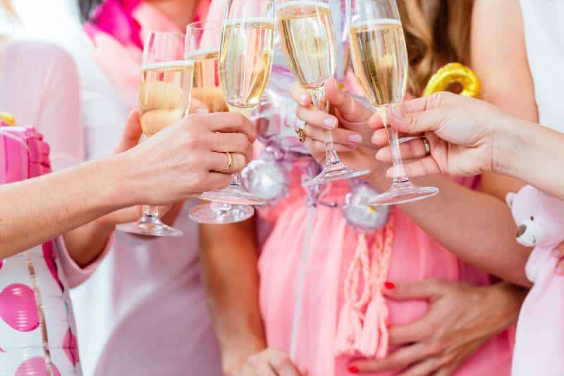 Friends clinking glasses on baby shower party