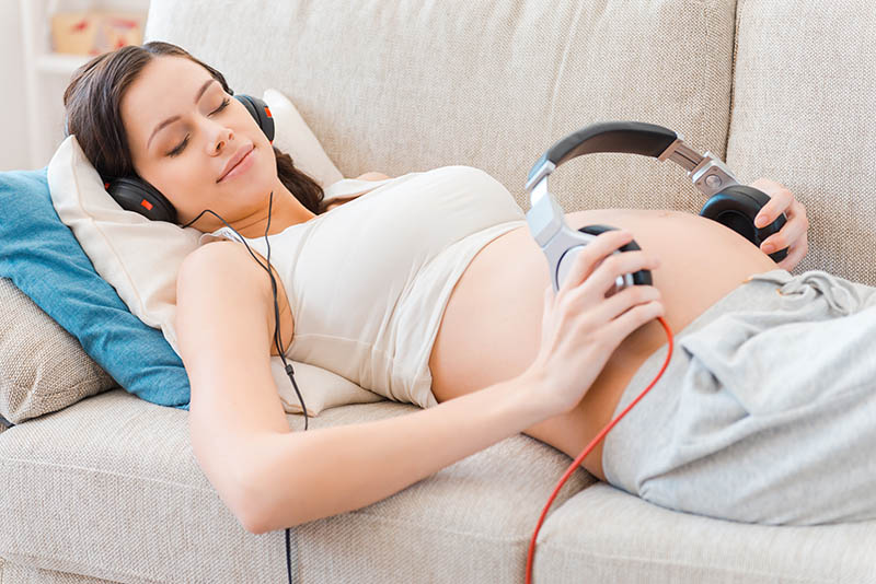 pregnant woman trying to move baby with music