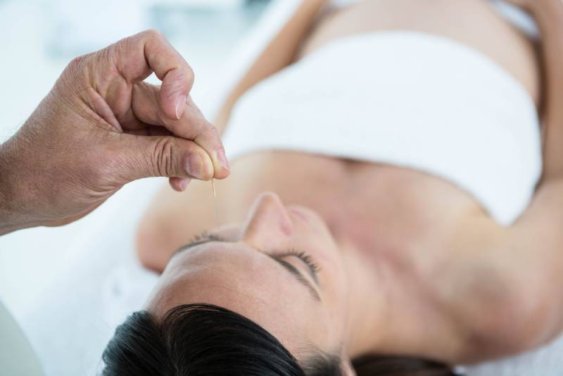 Pregnant woman in an acupuncture therapy at the health spa