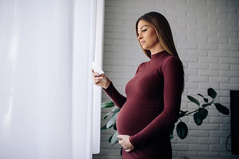 beutiful pregnant woman reading a note