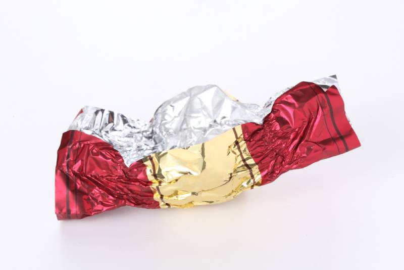 red and gold empty candy wrapper isolated on white background 