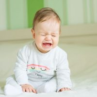 cute baby crying on the bed