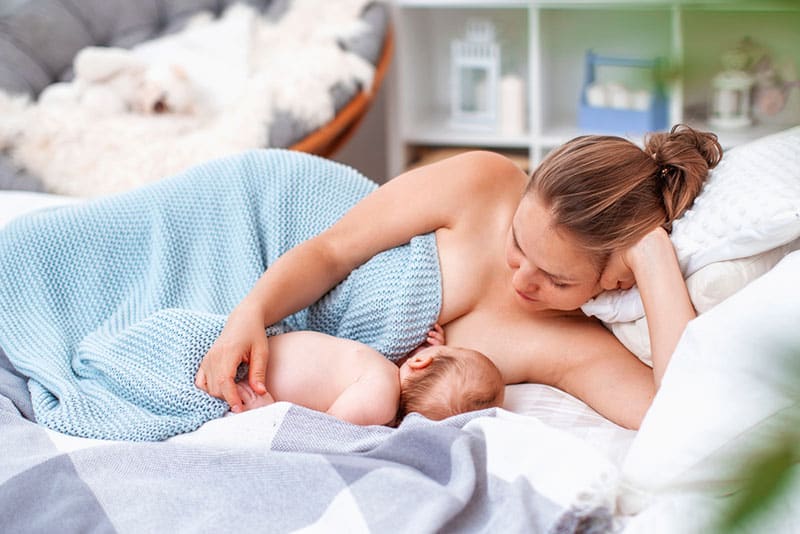 happy young woman breastfeeding her newborn baby