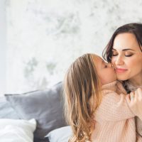 little girl kissing her mother