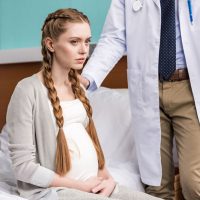 sad pregnant woman sitting at doctors