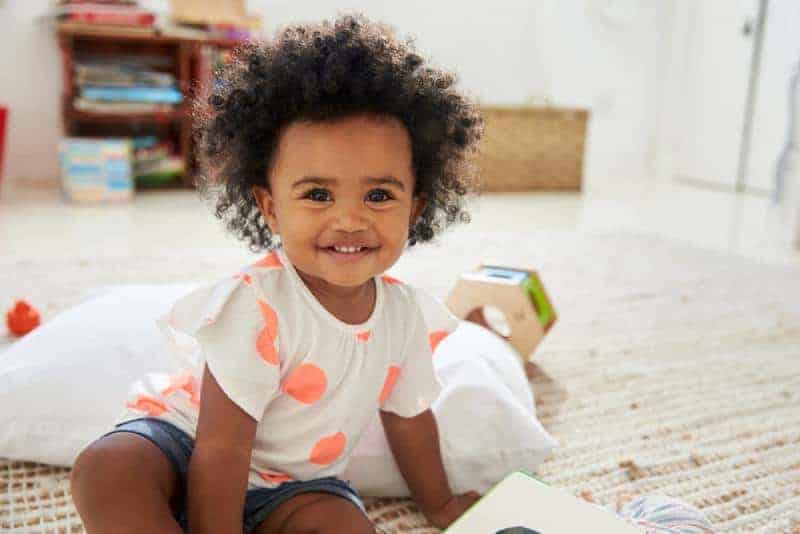 cute baby girl with curly hair smiling