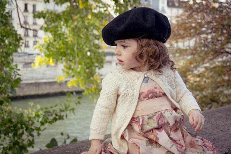 cute little girl with french hat sitting outdoor