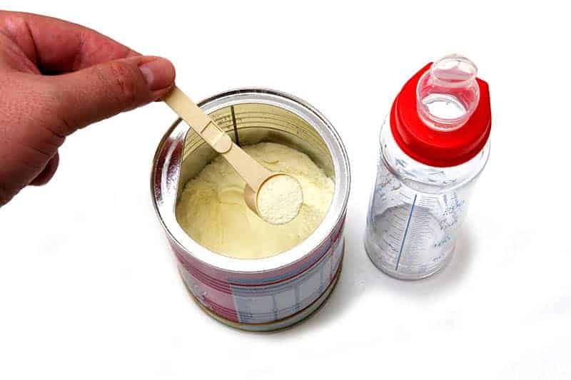 hand holding spoon with baby formula