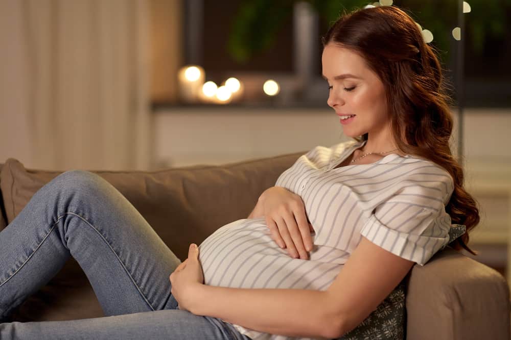 happy pregnant woman lying on the couch