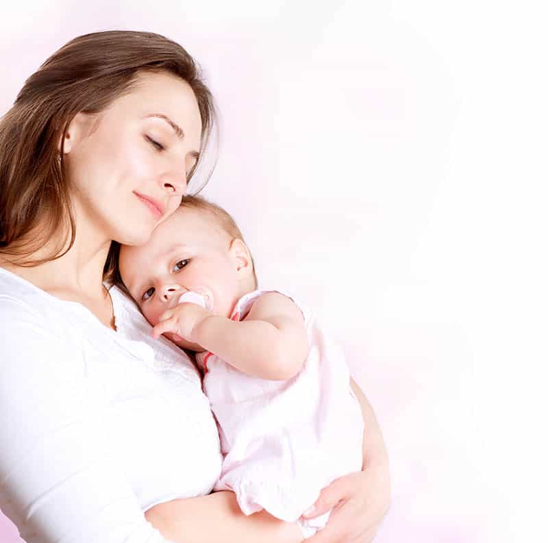 happy young mother holding baby with pacifier
