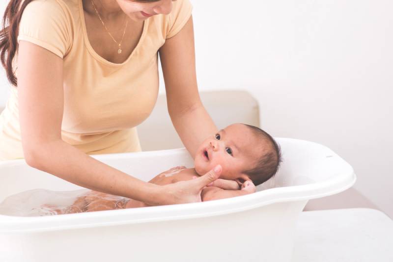 mother taking baby bath
