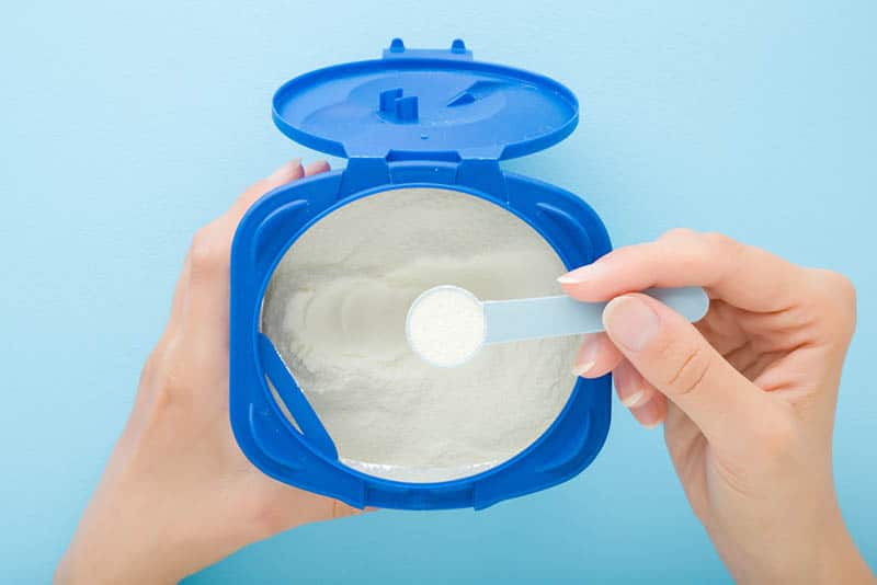 mother taking baby formula with spoon