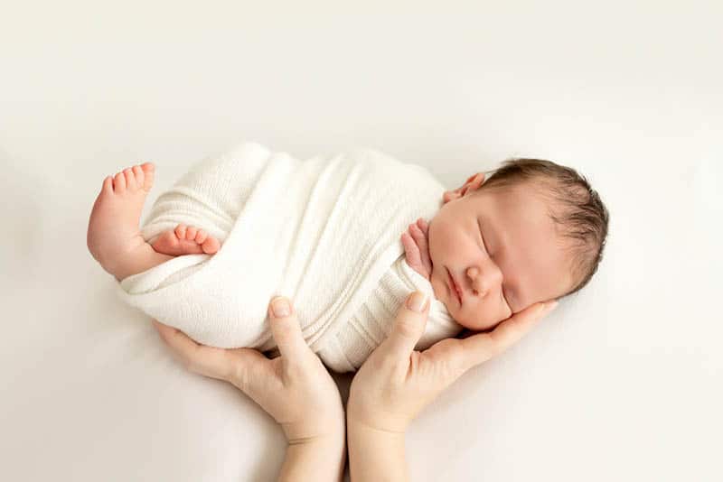 newborn baby sleeping in hands