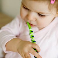 baby brushing teeths with colored brush