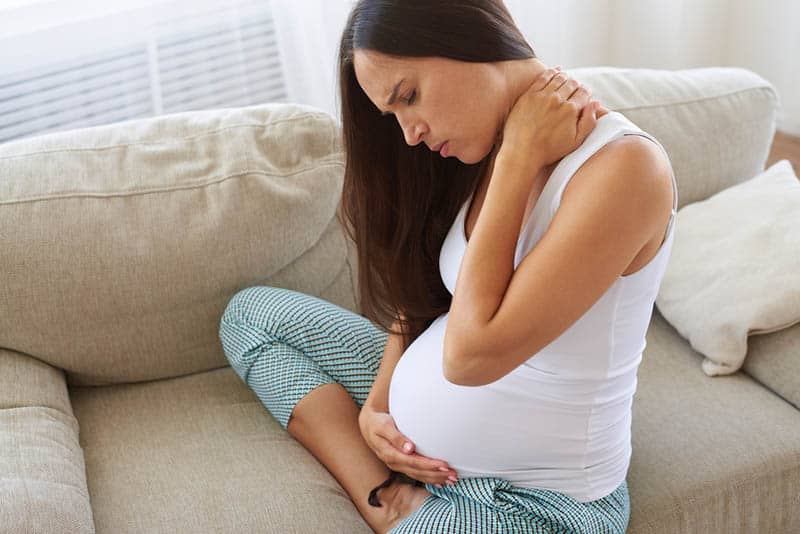 pregnant woman doing massage of painful neck