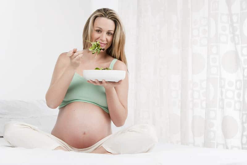 pregnant woman eating leafy greens