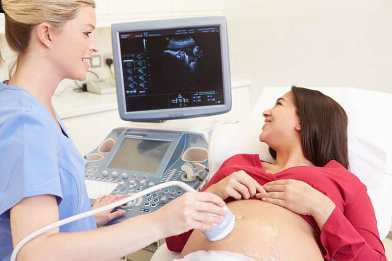 pregnant woman having and ultrasound scan of her baby at doctors
