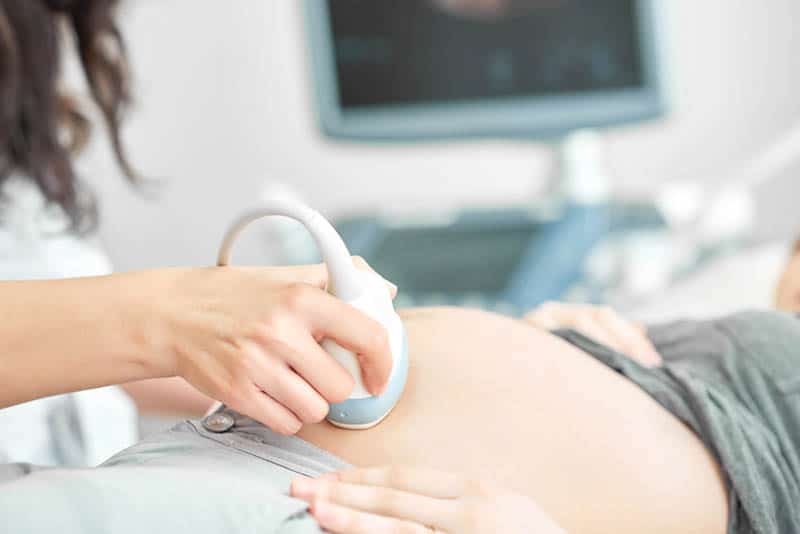 pregnant woman on ultrasound with doctor