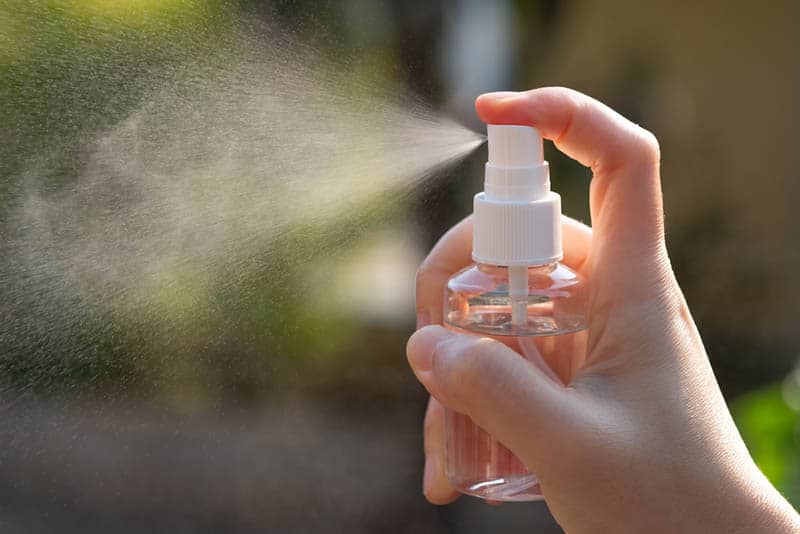 woman using antiseptic spray