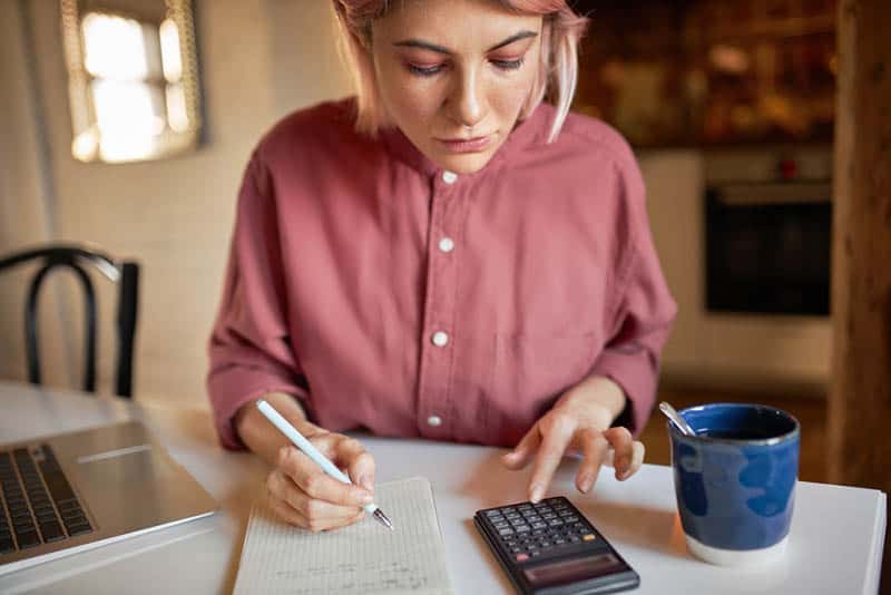 serious woman planning money budget and writing it down