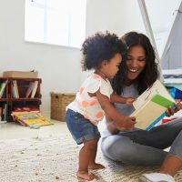 mother reading with baby girl in a room