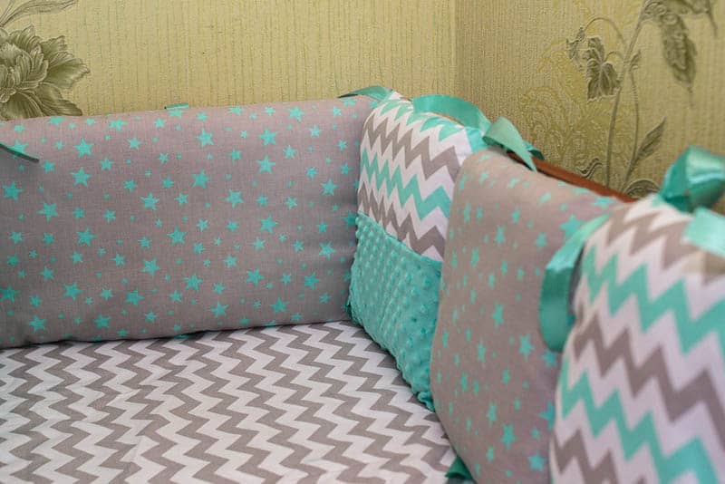 toddler bed with colorful baby bumpers for protection