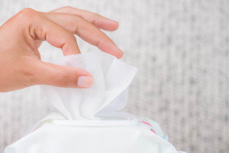 woman pulling out wet baby wipe from package