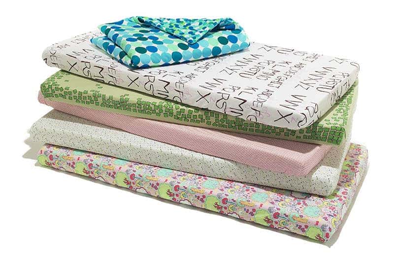 a few baby crib sheets in different colors and designs 