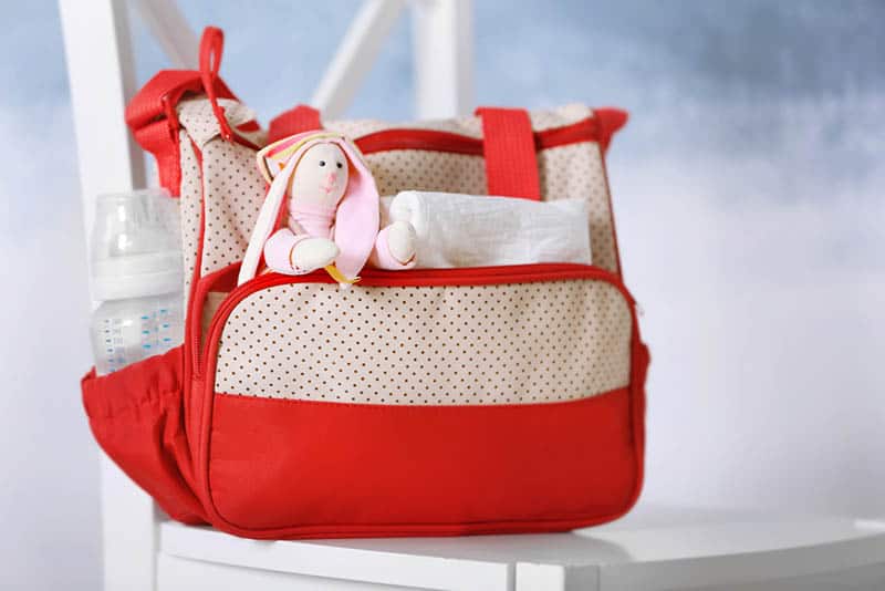 baby diaper bag for moms with baby items on the white chair