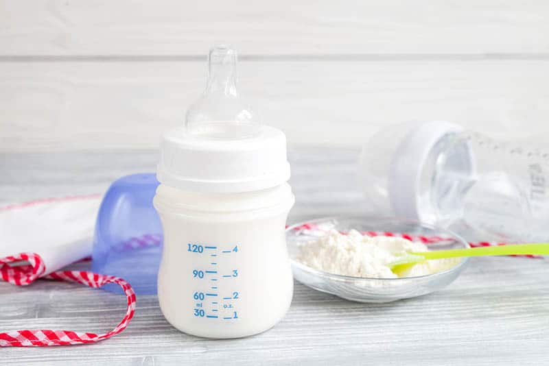 baby milk bottle with baby formula on the little glass plate