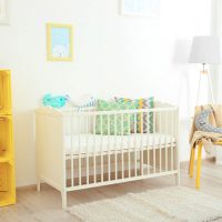 a crib and yellow furniture in the nursery