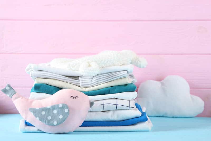 complex baby clothes with toys on the blue table