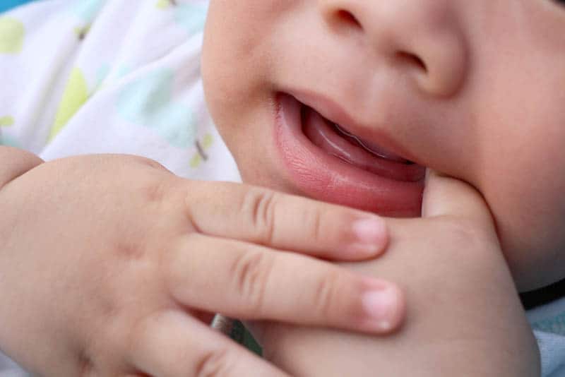 cute baby sucking finger beacuse of teething